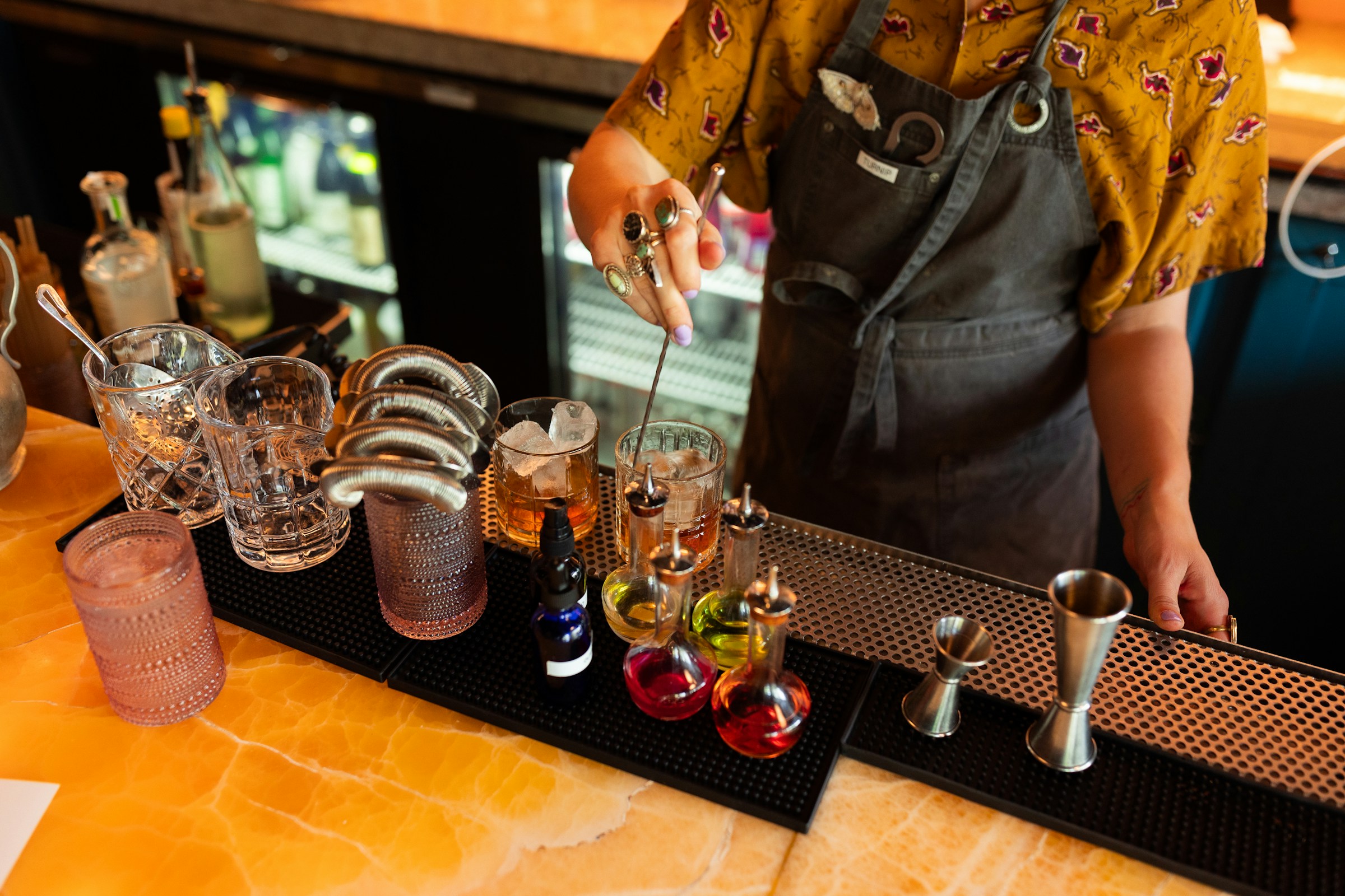 Photo by <a href="https://unsplash.com/@negley?utm_content=creditCopyText&utm_medium=referral&utm_source=unsplash">Negley Stockman</a> on <a href="https://unsplash.com/photos/a-man-standing-behind-a-bar-filled-with-glasses-sYQpnt_2D8k?utm_content=creditCopyText&utm_medium=referral&utm_source=unsplash">Unsplash</a>